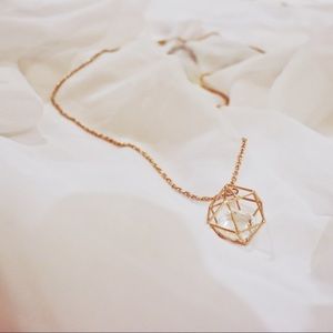 Long gold necklace with jewel cage ball